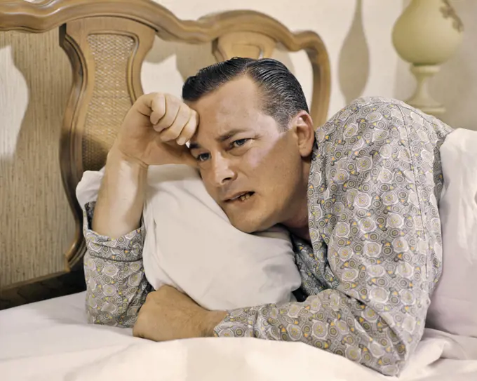 1950s 1960s MAN IN BED AWAKE LOOKING DISTRESSED INSOMNIAC WORRIED PRINT PAJAMAS