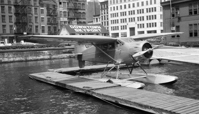 1930s 1939 WACO AIRPLANE ON FLOATS IN EAST RIVER AT WALL STREET DOWNTOWN SKYPORT NEW YORK CITY USA