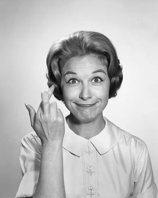 1960s WOMAN FUNNY FACIAL EXPRESSION WITH FINGERS CROSSED FOR LUCK LOOKING AT CAMERA