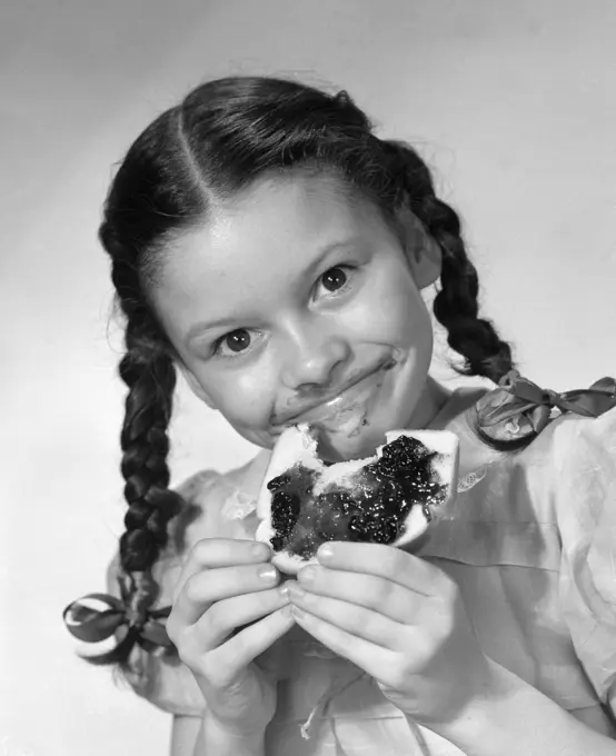 1950S Girl With Pigtails Eating Bread With Jelly Smeared On Her Face