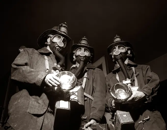 1950S Trio Of Rescue Squad Firemen Wearing Respirator Masks Carrying Flashlights And Fire Equipment