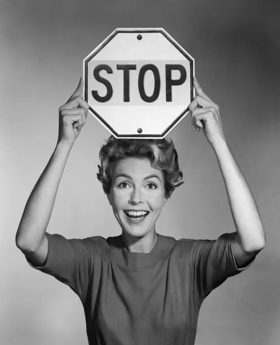 1960S Smiling Woman Holding Stop Sign Above Her Head