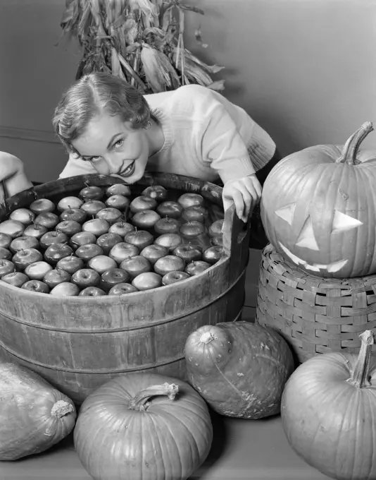 1950S Smiling Woman Leaning Over Wooden Tub Filled With Water About To Begin Bobbing For Apples