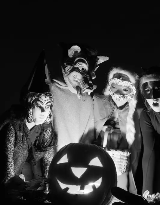 1960S Group Of Four Children In Halloween Costumes Gathered Around Jack-O'-Lantern Indoor