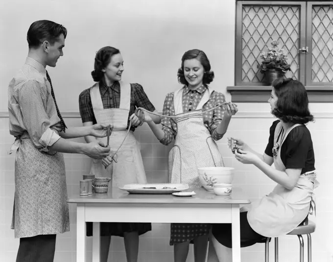 1930S 1940S Women 1 Man Aprons In Kitchen Pulling Taffy