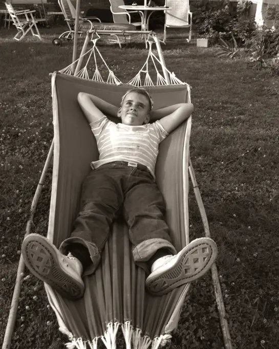 1950S Relaxed Smiling Boy Lying In Suburban Backyard Hammock