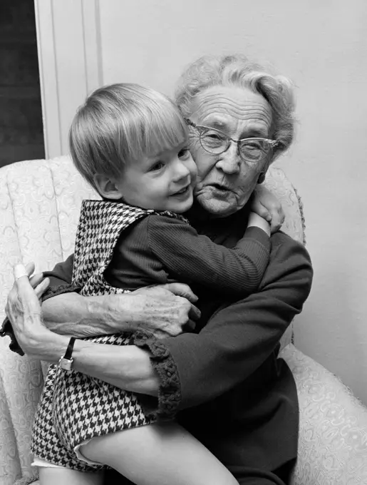 1960S Grandmother In Chair Hugging Grandson In Checkered Shorts