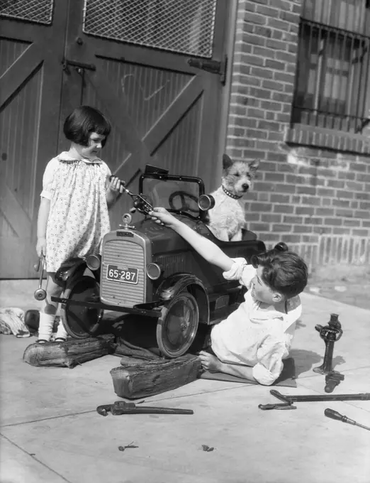 1930S Two Children Boy Girl And Dog Fixing Toy Automobile