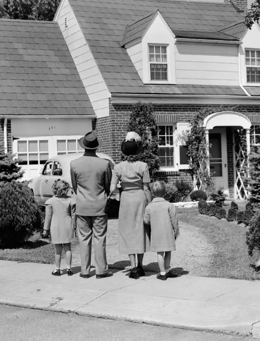 1940S Family Mother Father Daughter Son Looking At Suburban House Back View Outdoor