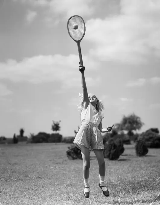 1930S Girl Playing Tennis Jumping To Hit Ball Overhead