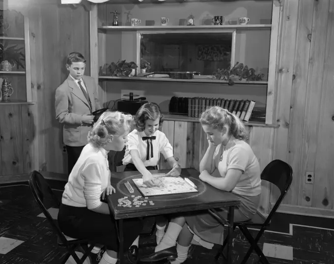 1950S Girls Playing Scrabble In Rec Room With Boy Changing Records