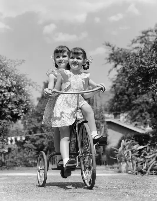 1940S Twin Girls Riding Outside On Tricycle