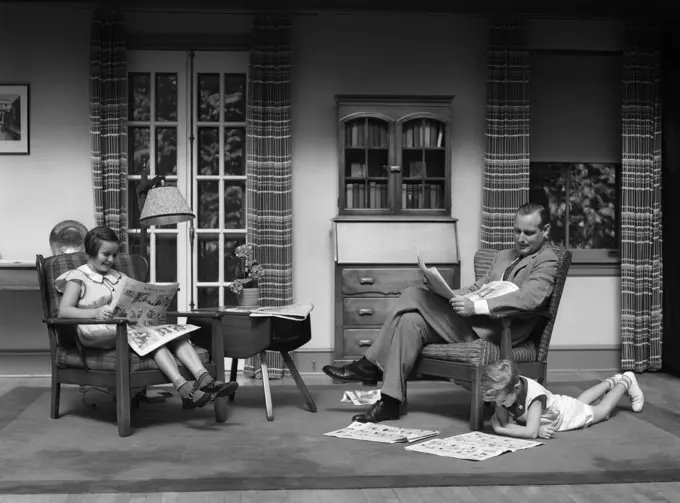 1930S Man Father Reading Newspaper Boy Girl Reading Comics In Living Room