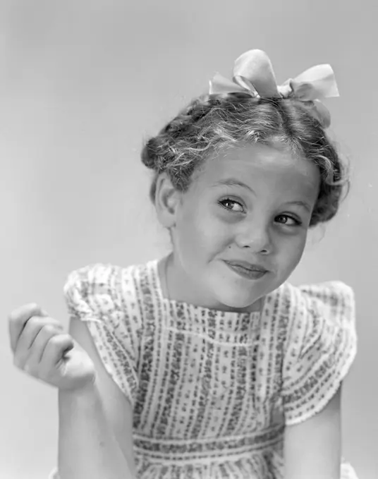 1940S Little Girl Smiling Smirking Looking Off To One Side