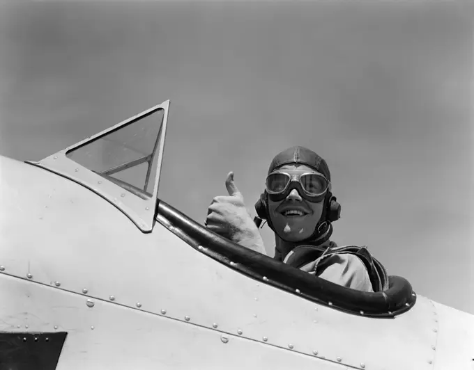 1940S Smiling Army Air Corps Pilot In Open Cockpit Wearing A Leather Flying Helmet Giving A Thumbs-Up Sign