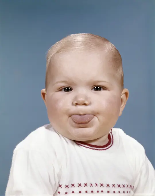 1960S Portrait Of Cute Blond Chubby Baby Looking At Camera Sticking Out Tongue