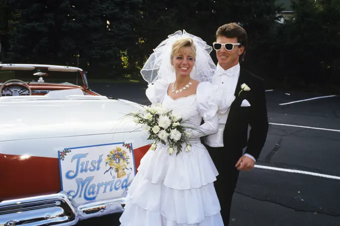 1991 Bride And Groom Standing Next To Vintage Convertible Ford Automobile