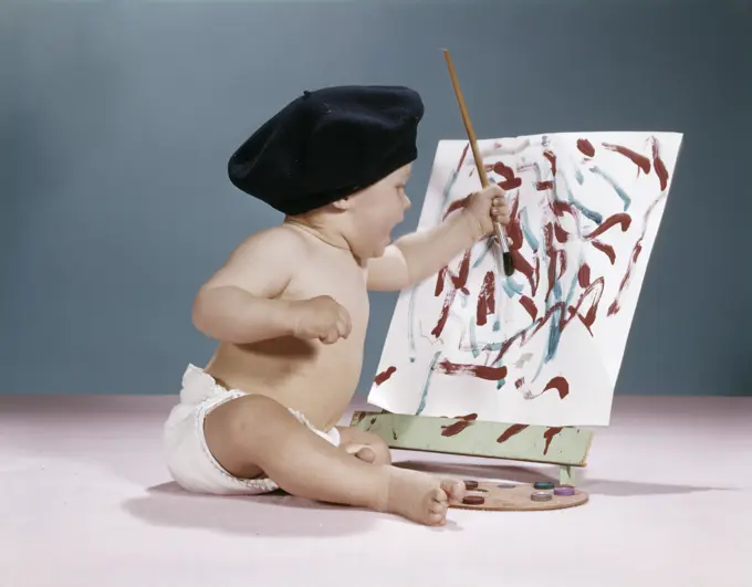 1960S Baby Artist Wearing Black Beret Sitting In Front Of Easel Painting