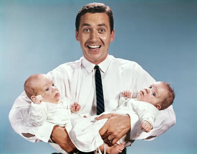 1960S Smiling Man Father Looking At Camera Holding Twin Babies Infants