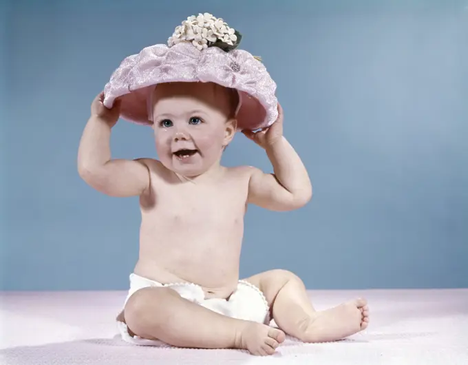 1960S Smiling Baby Girl Wearing Diaper And Large Pink Hat