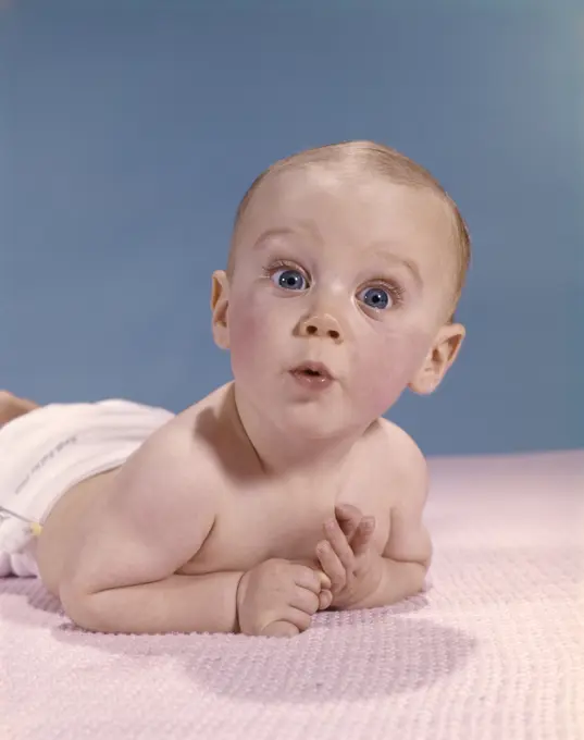 1960S Baby Laying On Stomach Looking Surprised