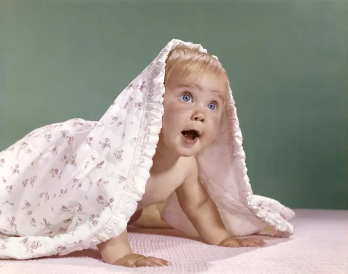 1960S Baby Crawling And Peeking Out From Under A Blanket