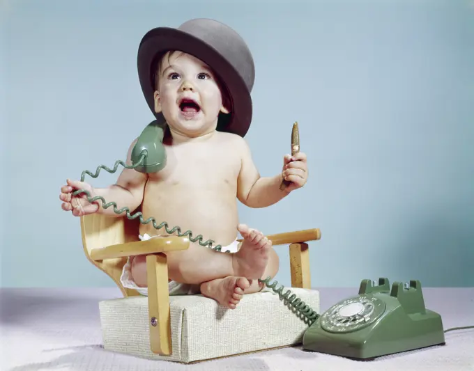 1960S Baby Boy Sitting Booster Chair Holding Cigar Wearing Hat Holding Telephone