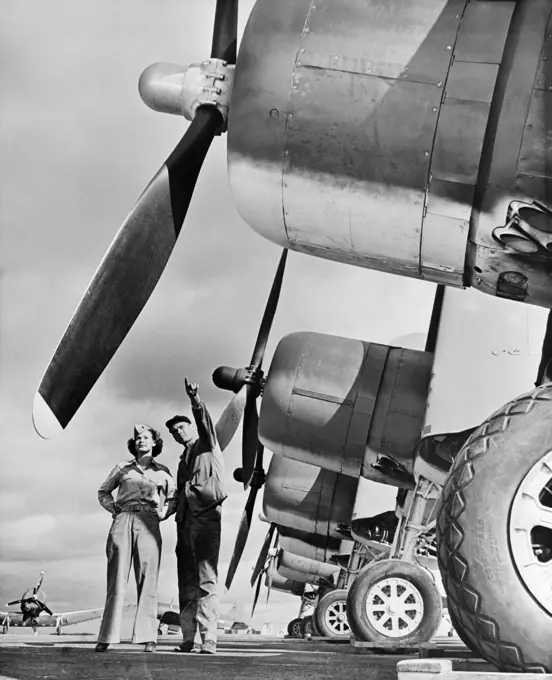 1940S Wwii Marine Corp Technician With Woman Reservist Inspecting Fighter Aircraft On The Air Field