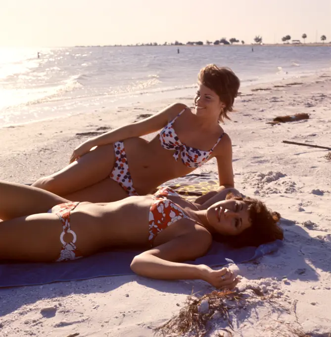 1970S Two Women Lying Sand Beach Smiling Wearing Print Fabric Bikini Swim Wear Bathing Suits