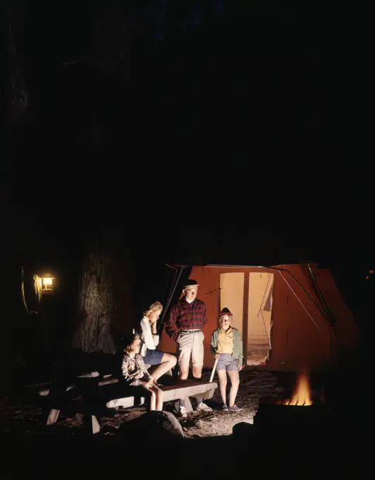 1960S Night Scene Family Gazing Into Campfire By Tent  