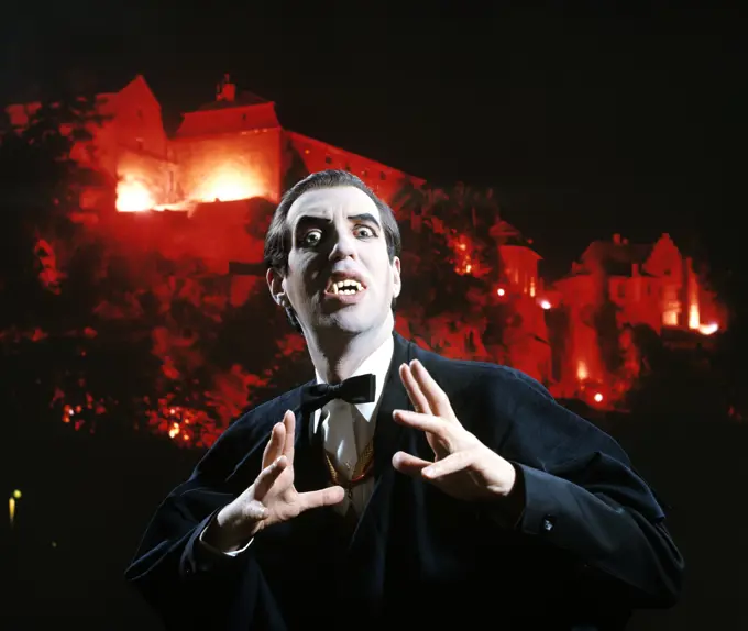 Man In Vampire Makeup And Costume Gesturing Menacingly Castle Background Studio Superstition Folklore