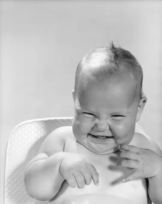 Adorable baby giggling in black and white photo - happiness and innocence