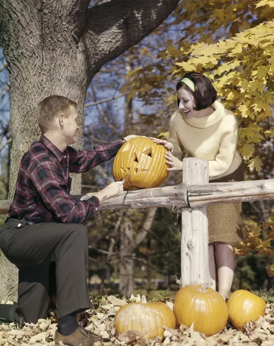 1960S Young Couple Man Woman In Autumn Woods Carving Halloween Jack-O-Lantern Pumpkin