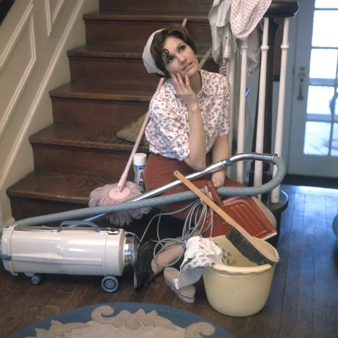 1960S 1970S Tired Bored Young Woman Daydreaming Sitting On Stairs Surrounded By House Cleaning Tools