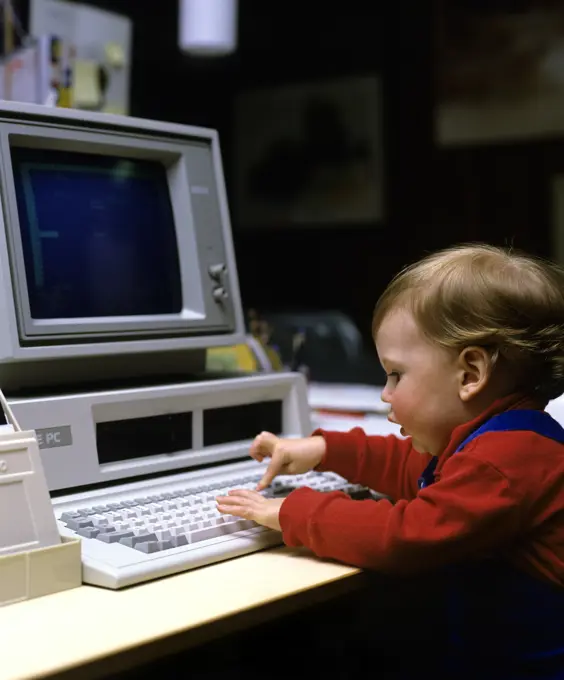 1980S Young Child Boy Girl Playing With Early Ibm Pc Computer Pressing Key On Keyboard