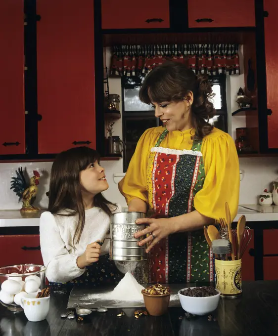 1980S Mother And Daughter Baking Sifting Flour In Kitchen