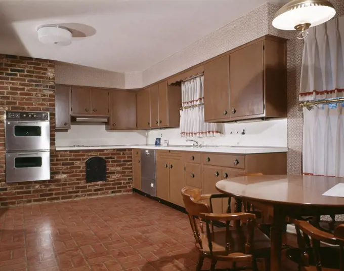 1980S Kitchen With Dark Wooden Cabinets Brick Wall And Stainless Steel Double Oven