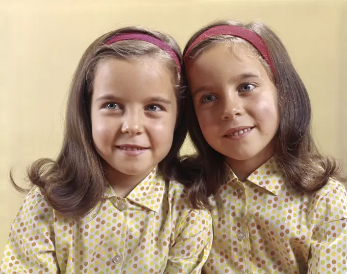 1960S Portrait Smiling Twin Sisters Wearing Identical Head Bands And Cotton Print Polka Dot Shirts