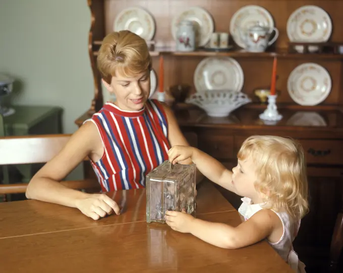 1970S Mother And Daughter With Piggy Bank