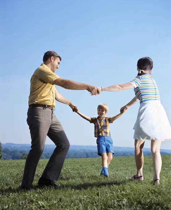 1970S Family Mother Father Boy Playing Ring Around Roses Holding Hands Circle Man Woman Child