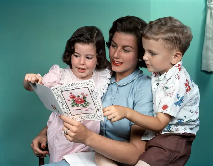 1950S Mother Looking At Greeting Card With Children 