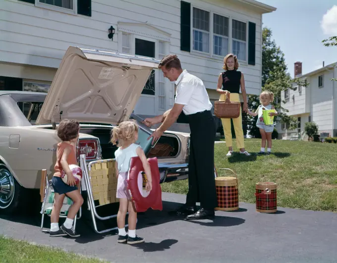 1960S Family Mother Father Three Daughters Packing Luggage Into Car For Vacation Outdoor