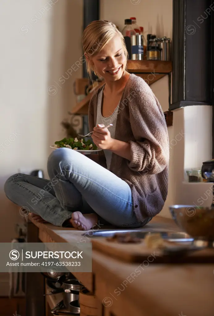 Happy, woman and eating salad in kitchen at home, nutrition and fresh leafy greens for healthy diet. Vegetables, bowl and smile of hungry person with food, lunch or organic vegan meal for wellness