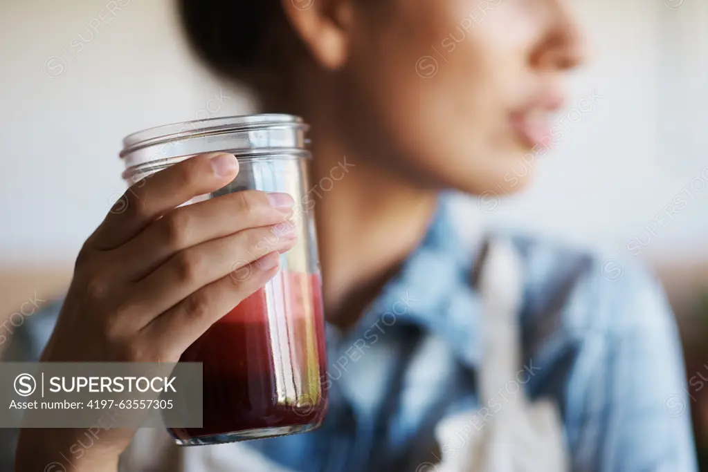 Glass, hand and smoothie with woman in kitchen of home closeup for diet, health or nutrition. Detox, juice for weight loss and person in apartment with fresh fruit beverage for minerals or vitamins