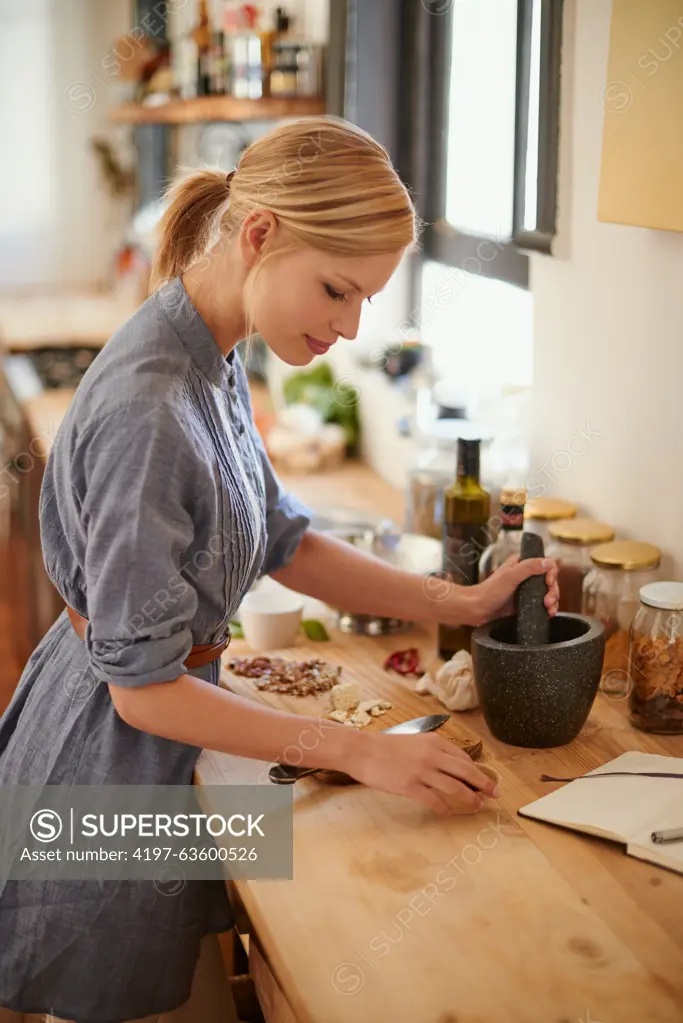 Cooking, woman and mortar with grind in a home with diet, nutrition and healthy food with pestle. Kitchen, bowl and happy from organic and vegan lunch with mushroom and wood board with wellness