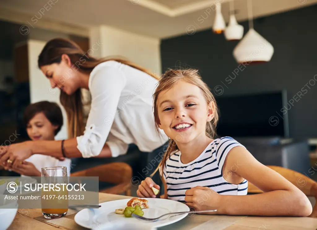 Family, breakfast and portrait of girl at table for diet, nutrition and gut health support. Love, food and face of kid with mother for brunch, meal and wellness with fruit, vitamins or development