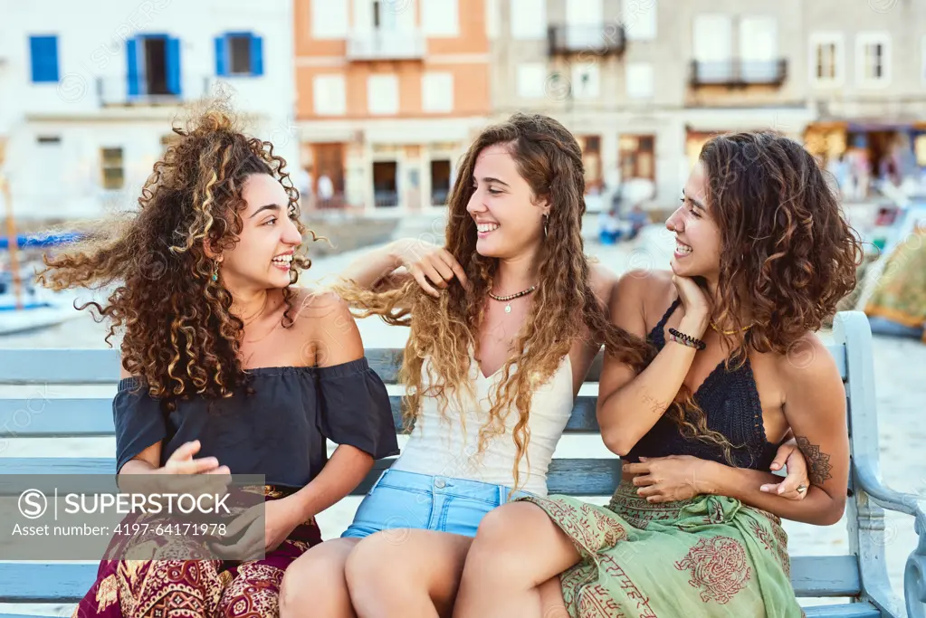 Happy, conversation and women in city for holiday, summer vacation and adventure together. Travel, fashion bench and friends talking, chat and relax for journey, bonding and tourism in Barcelona