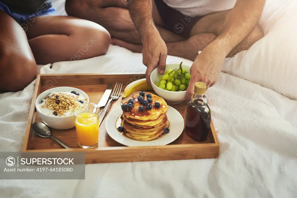 Couple, morning or hands for breakfast in bed for wellness, brunch or food bowl together to relax in home. Valentines day, wake up or people eating for healthy diet, nutrition or orange juice closeup