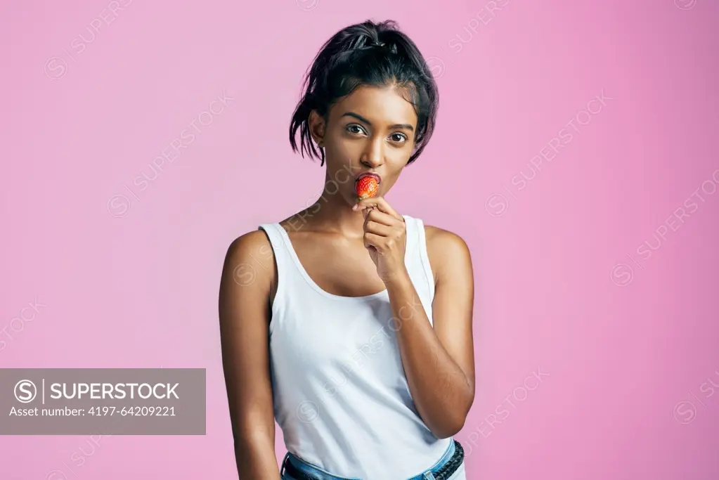 Portrait, strawberry and hands of woman in studio for fruit, nutrition diet or healthy snack on pink background. Food, vitamin c and Indian model for detox, antioxidants or weight loss with mockup