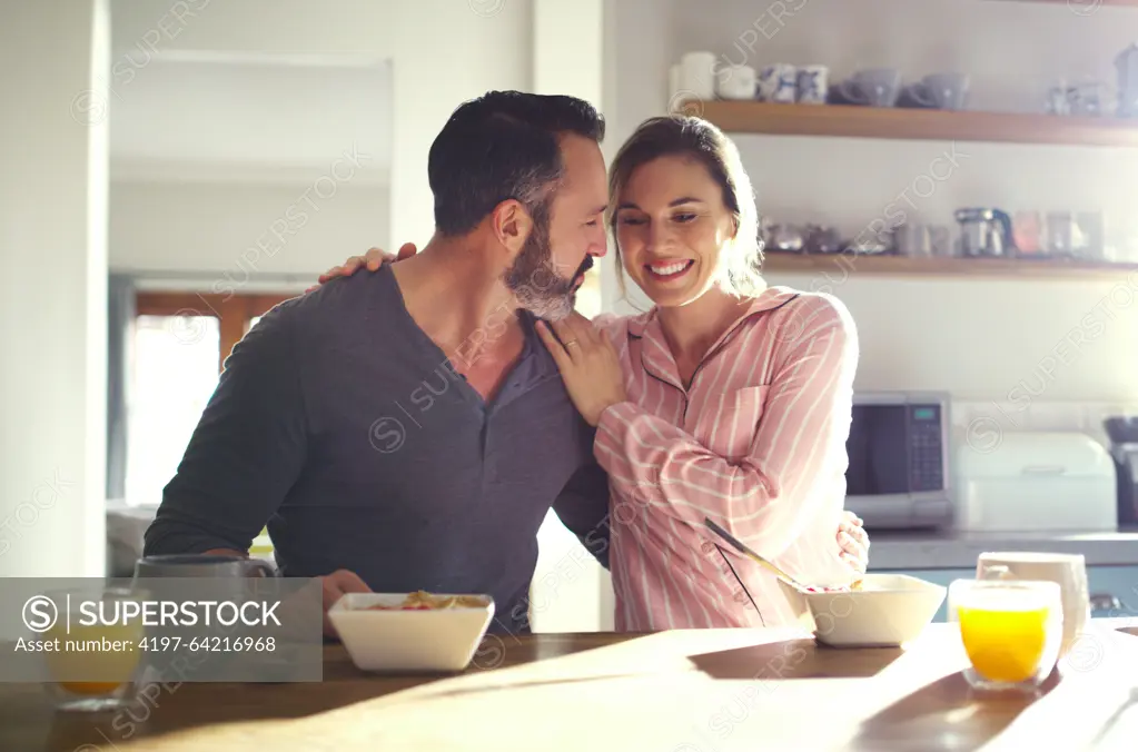 Happy couple, hug or eating breakfast with cereal, diet or juice in morning meal in house kitchen. People, trust or snack in bowl for bonding, funny joke and food in healthy marriage or love together